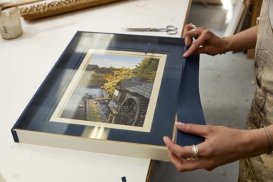 Deux mains tenant un cadre avec une photo à l'intérieur